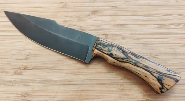 Left side of Spalted Pecan harpoon clip point knife featuring stabilized Florida pecan handle and mild steel pins