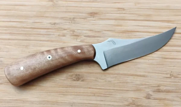 View of the right hand side of a custom Black Olive Trailing Point #311 knife with a creamy wood handle and Mosaic Pin