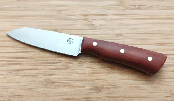 Left Full view of Modified Santoku Paring Knife, red cedar with brass pins on wooden surface