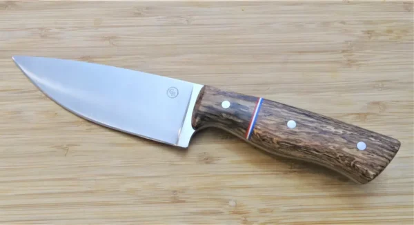 Left side of Burr Oak with Spalted Pecan bolster Big Camper Knife and red, white, blue G10 spacers, on wooden surface