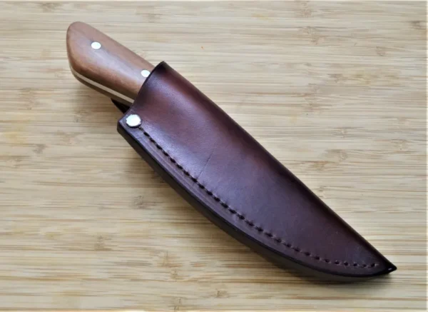 Wild Black Cherry Goldilocks #211 EDC knife in a custom leather pouch sheath, featuring the wild black cherry wood handle on a wooden background