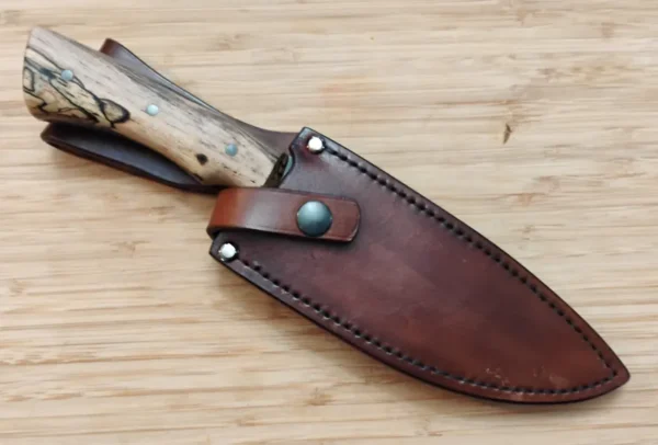Custom Spalted Pecan harpoon clip point knife in hand-cut leather sheath with retention strap.