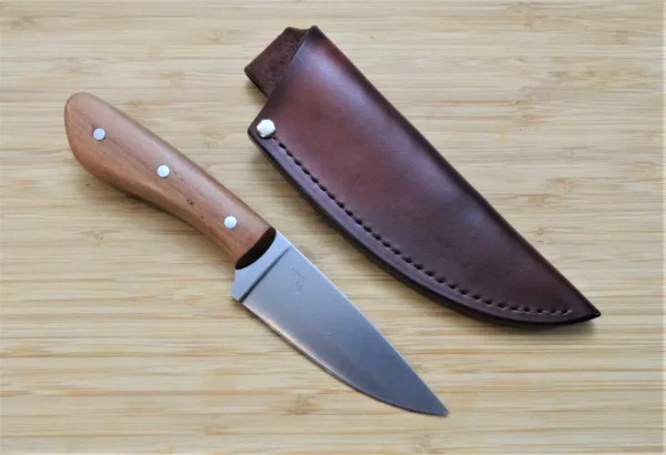 EDC knife next to a custom hand-cut leather sheath, featuring the Wild Black Cherry Goldilocks #211 with a wild black cherry wood handle