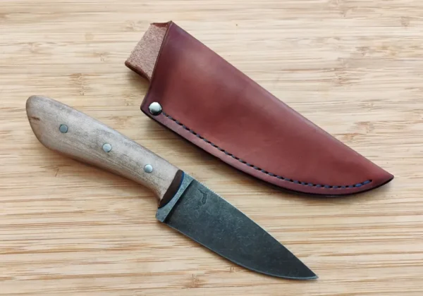 Red Maple Goldilocks #271 knife next to a custom hand-cut leather sheath, featuring the Drop Point EDC with a stonewashed blade