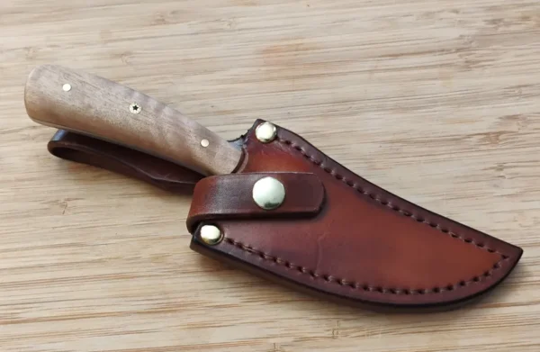South Florida Black Olive Trailing Point #311 knife in a custom leather sheath, displayed the beauty of the Black Olive handle