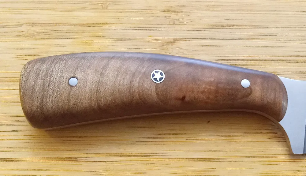 Florida Wood Series- Cross Cut Red Maple custom knife handle that shows swirling figuring of the wood on a wood background