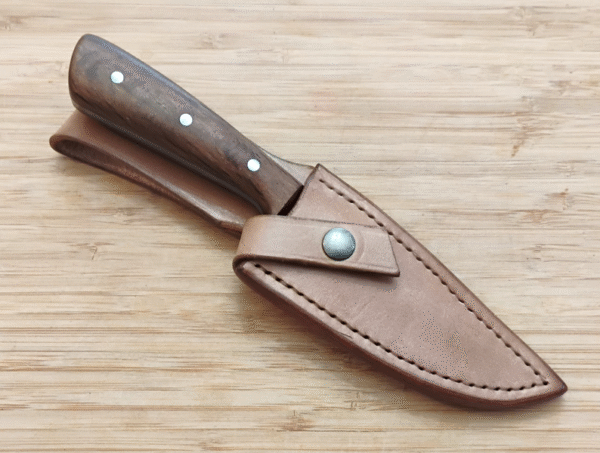 Live Oak Drop Point #358 hunting knife in its Live Oak bark-dyed leather sheath with secure snap closure.