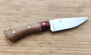 Black Olive Hunter #355 a 8 1/2” 1095 high-carbon steel clip point blade, Red Cedar bolster, , displayed on a wooden surface.